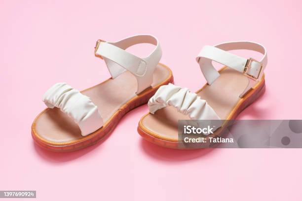 Female Beige Sandals On A Pink Background Closeup Stock Photo - Download Image Now