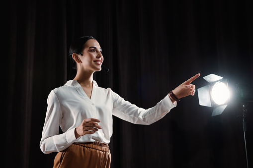 Motivational speaker with headset performing on stage