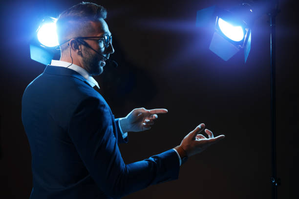 istock Motivational speaker with headset performing on stage. Space for text 1397691252