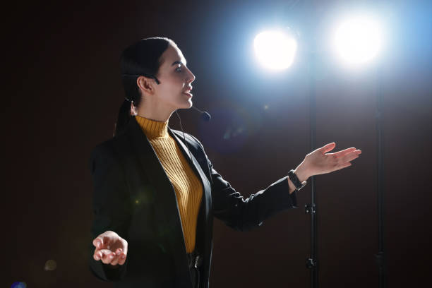 Motivational speaker with headset performing on stage