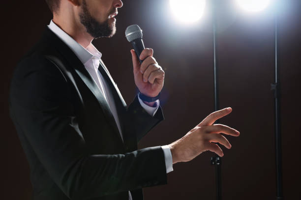istock Motivational speaker with microphone performing on stage, closeup 1397691944