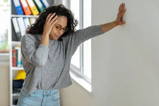 Woman suffering from dizziness with difficulty standing up