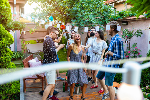 Group of pretty young people have a summer party in a backyard