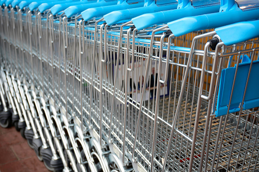 A lot of shopping trolleys. Blue modern supermarket shopping carts in a row.