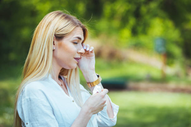istock Young woman sneezing in park. 1397696336