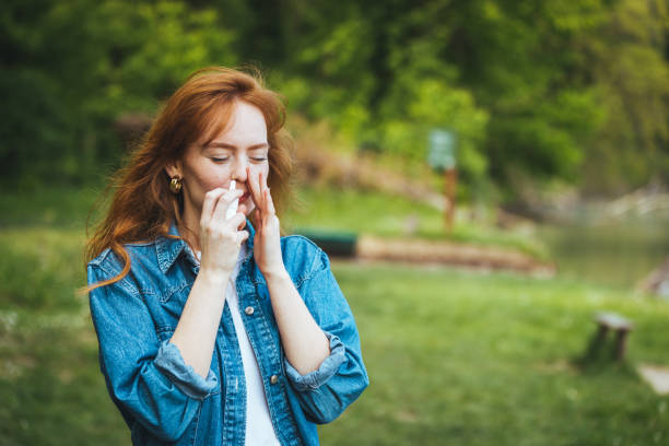 Woman is having flu and she is using nasal spray to help herself. Woman is having flu and she is using nasal spray to help herself. Woman using nasal spray. Nasal spray to help a cold. Sick with a rhinitis woman dripping nose. Woman applies nasal spray human nose stock pictures, royalty-free photos & images