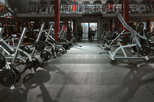 Large group of exercise machines and equipment in a gym.