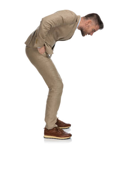 istock middle aged guy in beige suit looking down and trying to see something really small 1397697200
