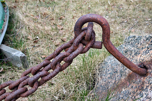 Close-up of a rusty chain connected to a rusty tube on a shipyard. With copy space. Shot with a 35-mm full-frame 61MP Sony A7R IV.