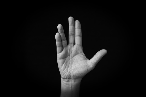Dramatic black and white image of Vulcan Salute emoji isolated on black background