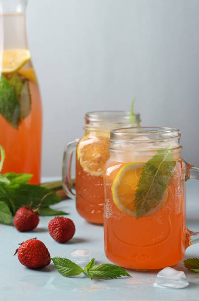 istock Lemonade or cocktail rhubarb, strawberry, mint, lemon and ice on light blue background. Vertical format 1397697588