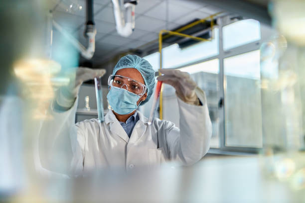 African American scientist working on antiviral drug in laboratory. Young black chemist analyzing and comparing liquids while working on scientific research in laboratory. biochemist stock pictures, royalty-free photos & images
