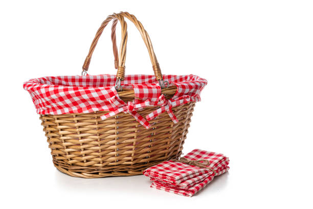 Front view of an empty picnic wicker basket and checked napkins isolated on white background. High resolution 42Mp studio digital capture taken with SONY A7rII and Zeiss Batis 40mm F2.0 CF lens