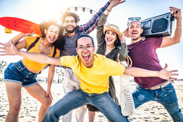 Multiracial group of friends enjoying holiday at beach party - Happy young people having fun together hanging outside - Youth and summer vacation concept with guys and girls at music festival event grupo multirracial de amigos disfrutando de vacaciones en la fiesta en la playa - jóvenes felices divirtiéndose juntos colgando afuera - concepto de vacaciones juveniles y de verano con chicos y chicas en el evento del festival de música