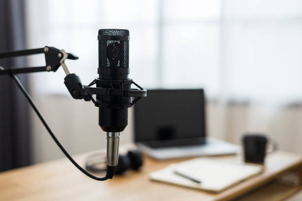 istock Condenser microphone in recording home studio. Content creator working with laptop host streaming radio podcast interview conversation at home broadcast studio recording voice over radio 1397703878