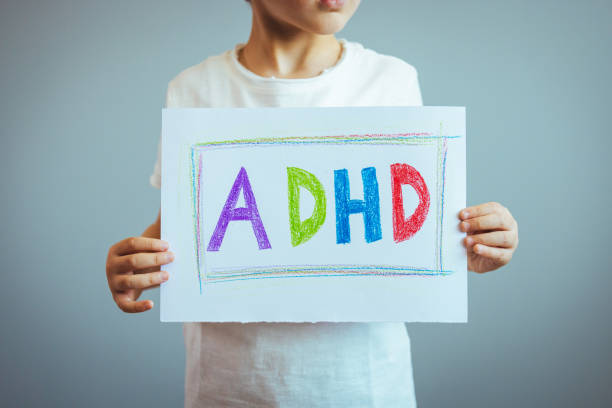 istock Young boy holds ADHD text written on sheet of paper. 1397706057