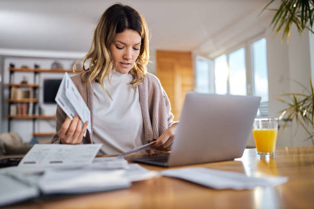 istock Young woman reading her home finances at home. 1397708108