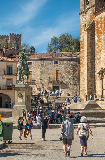 Trujillo, Spain - 16th April 2022. Tourists in the Plaza Mayor area of Trujillo. St Martin's Church is on the right, and the equestrian statue of Francisco Pizarro, the 'Conquistador of Peru' is left of centre.