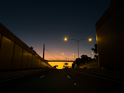 Driving on a freeway in the evening with an orange sunset