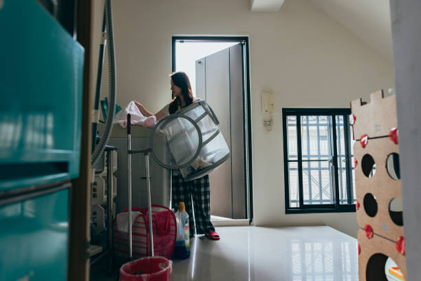 istock Young woman putting clothes into dry cleaning machine 1397710612