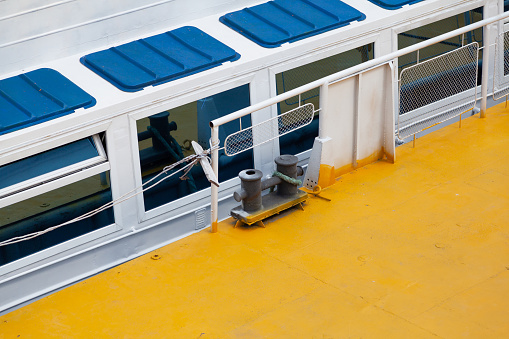A passenger ship stands in front of a yellow metal dock. On a white board, a row of blue hatches