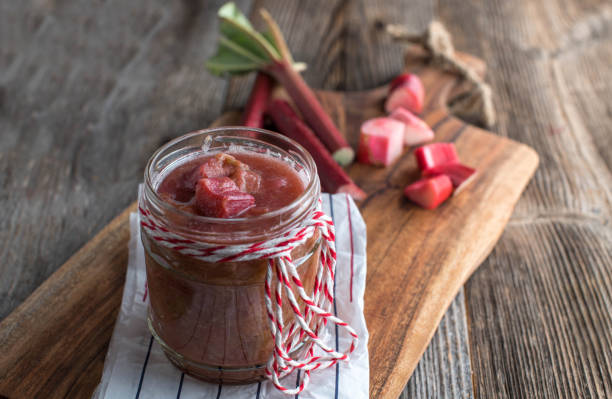 Homemade rhubarb compote Fresh cooked rhubarb compote. Served in a jar on wooden table background with copy space compote stock pictures, royalty-free photos & images