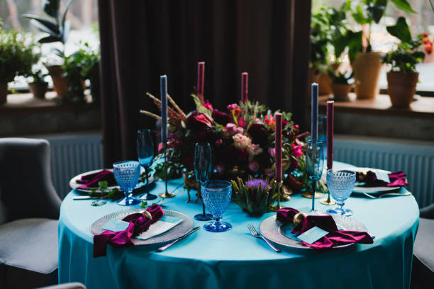 istock Table setting at the wedding reception. Floral compositions with beautiful flowers and greenery, candles, laying and plates on a decorated table. 1397718390