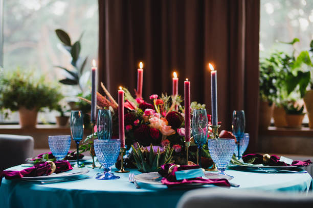 istock Table setting at the wedding reception. Floral compositions with beautiful flowers and greenery, candles, laying and plates on a decorated table. 1397718448