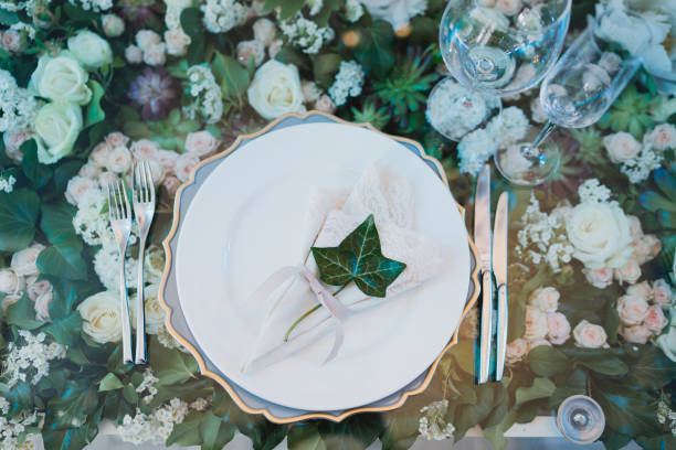 istock Table setting at the wedding reception. Floral compositions with beautiful flowers and greenery, candles, laying and plates on a decorated table. 1397719820