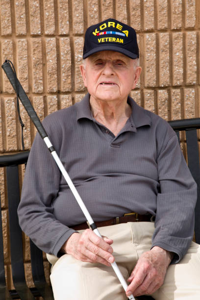 istock Blind Korean War veteran on bench holding a walking stick 1397723345