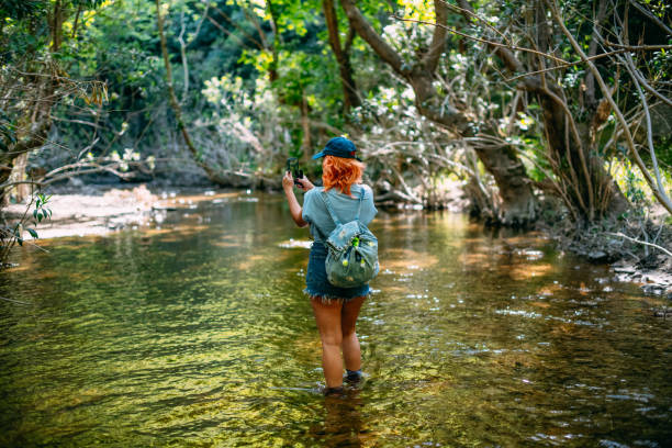 istock Hiking Woman Exploring River and Taking Photo 1397726580