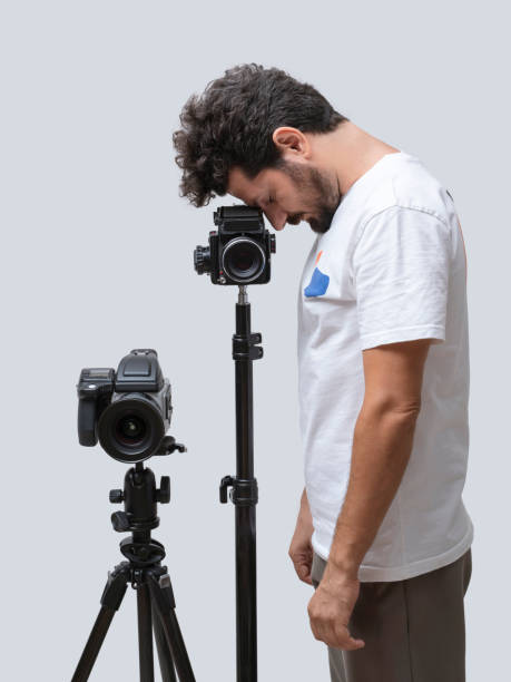 istock Photographer standing next to his camera, posing over white background 1397726600