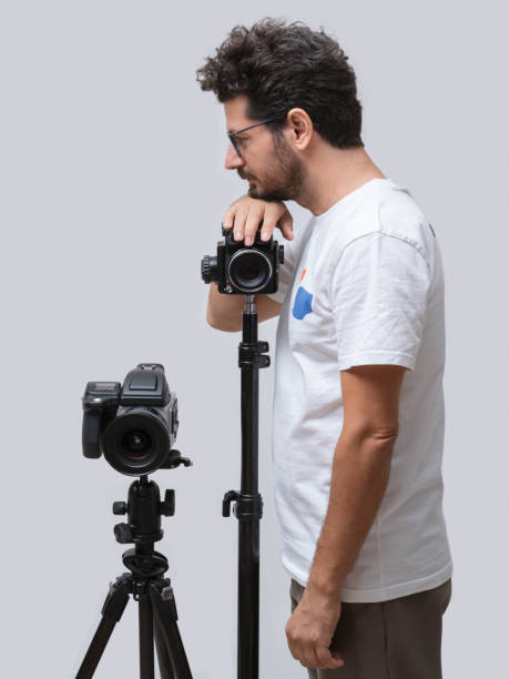 istock Photographer standing next to his camera, posing over white background 1397726655
