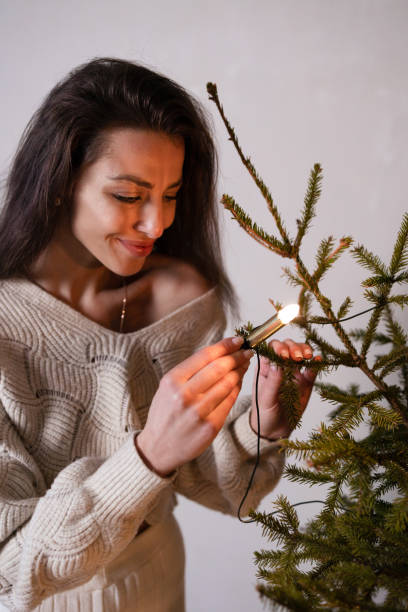 uma garota de moletom branco está perto da árvore de natal. - christmas tree standing clothing adventure - fotografias e filmes do acervo