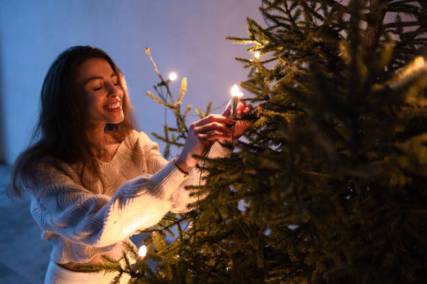 garota de suéter branco perto da árvore de natal - christmas tree standing clothing adventure - fotografias e filmes do acervo