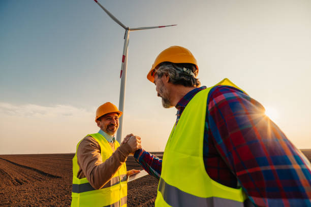 dos ingenieros trabajando en una central eléctrica de aerogeneradores - alternative energy electricity wind turbine team fotografías e imágenes de stock