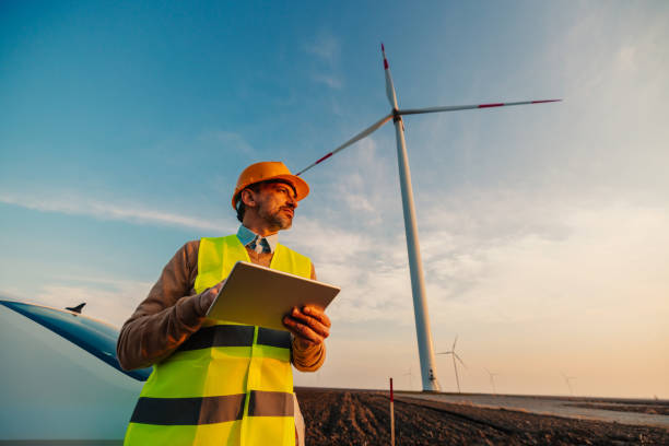 istock Engineer man looking and checking wind turbines at field 1397732351