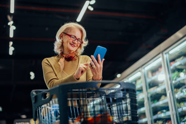 istock Mature woman using cellphone in supermarket 1397732930