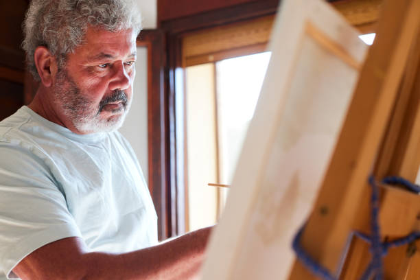 istock A retired senior man paints at home. 1397734369