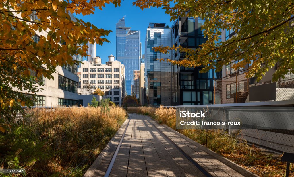 New York view of The High Line promenade in Fall. Elevated greenway with Hudson yards skyscrapers. Manhattan (Chelsea) New York view of The High Line promenade . Elevated greenway in Autumn with Hudson yards skyscrapers. Chelsea, Manhattan New York City Stock Photo