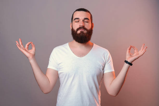 istock Bearded man with closed eyes is making the zen gesture in a studio. 1397735795