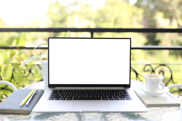 istock Laptop front view and coffee cup with notebooks on white glass table outdoor 1397736200