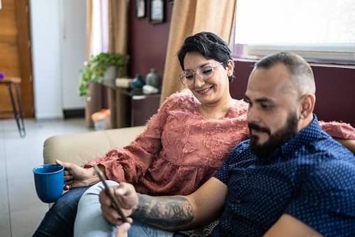 Mid adult couple using the mobile phone at home