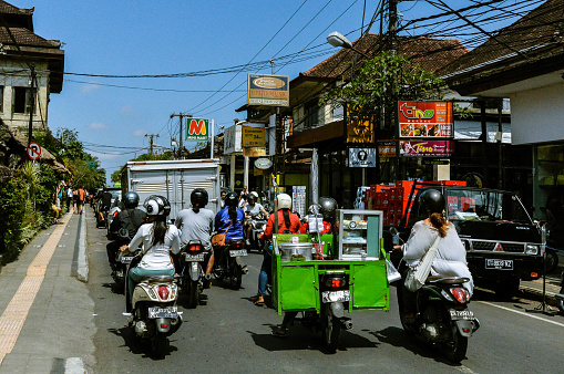 Traffic on Bali roads where mostly scooters drive, zig-zagging the cars on narrow roads. This photo was taken in September 2017