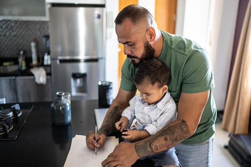 Father writing for his son at home
