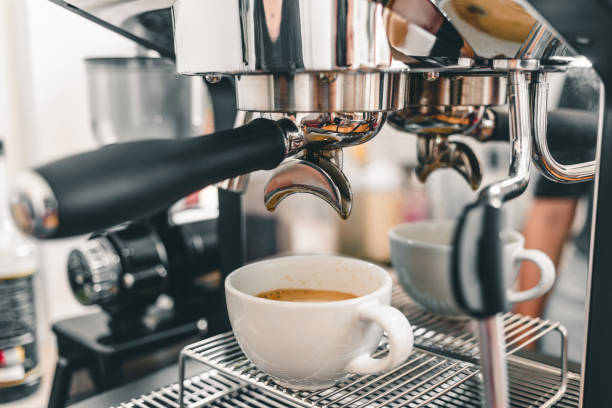 istock Coffee extraction from the professional barista coffee machine.Espresso pouring from a coffee machine in a cup of coffee at a coffee shop. 1397741192