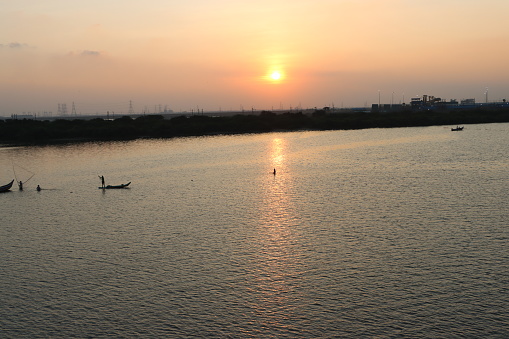 Fishermen Fishing  Silhoutte during Sunset at Ennore Creek, North Chennai, Tamil Nadu in India