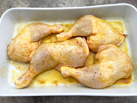 marinated with spices raw chicken legs ready for the oven