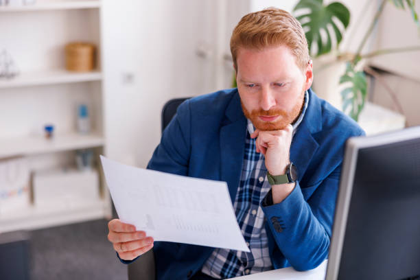 istock Businessman reading contracts while working in an office 1397742925