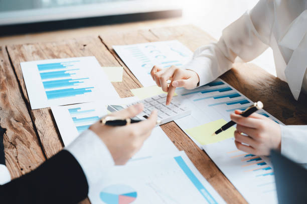 istock financial, Brainstorming, Data Analysis, Planning, Marketing and Accounting, Economist using calculator to calculate investment documents with partners on profit taking to compete with other companie. 1397743026